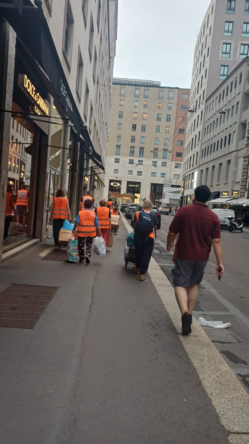 Volontari in cammino a Milano con carrelli e materiali destinati alla distribuzione
